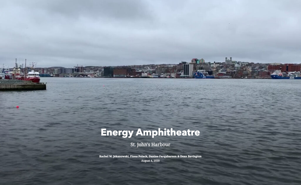 Harbour, grey sea and skies. Modern boats and buildings. Words: 'Energy Ampitheatre: St. John's Harbour, Rachel Webb Jekanowski, Fiona Polack, and Danine Farquharson